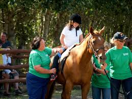 Girl riding a horse with the help of two guides